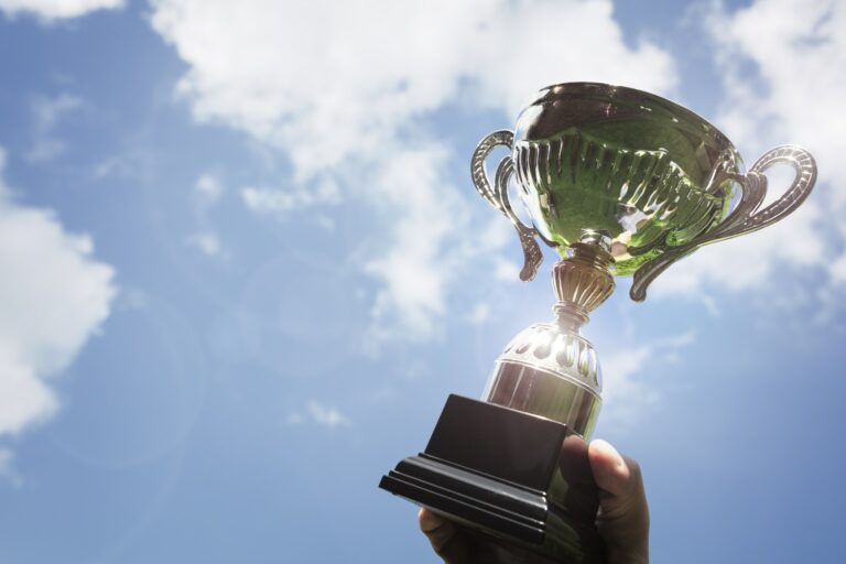 Holding up a trophy cup as a winner